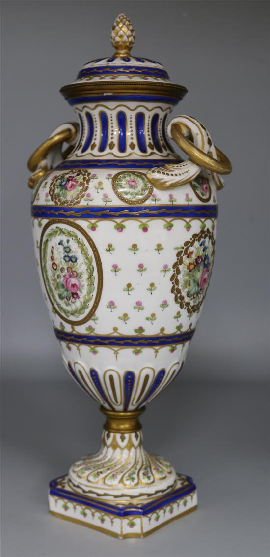 A Sevres style two-handled pedestal urn and cover, painted with flowers